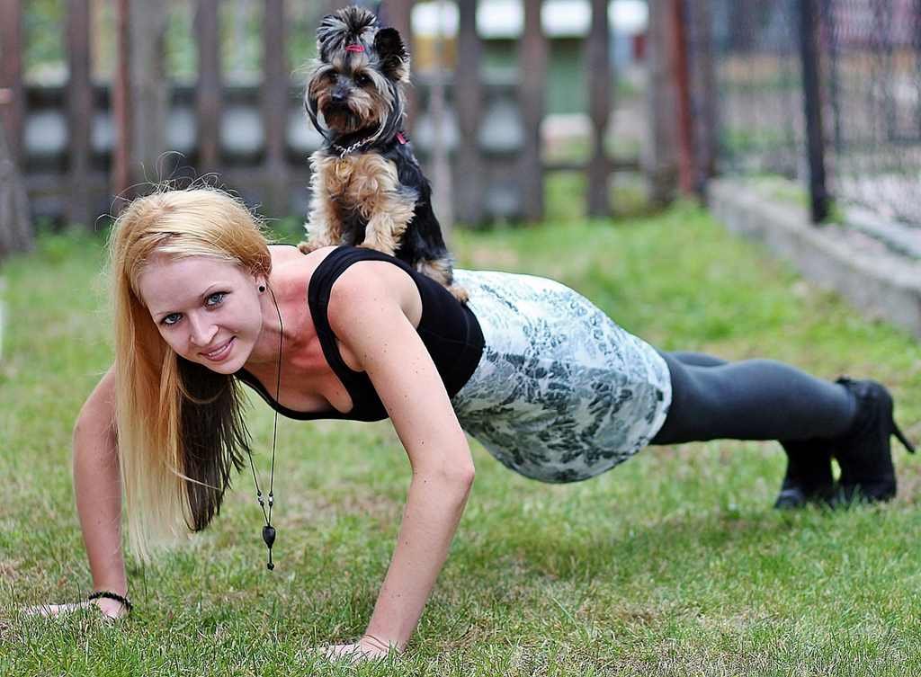 woman doing push up with dog